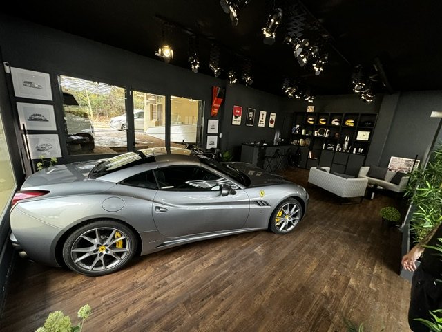 A silver Ferrari California parked on the timber floor of the Quattro Automotive showroom
